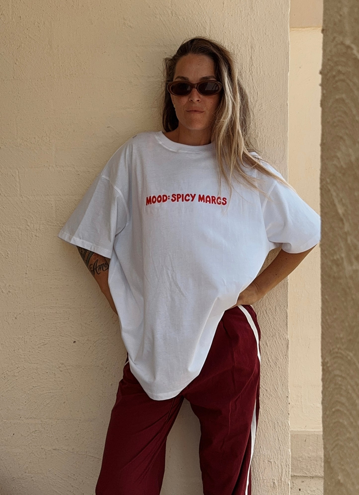 Woman wearing 'MOOD: SPICY MARGS' oversized t-shirt in white, showcasing the 100% cotton fabric and relaxed stylish fit.