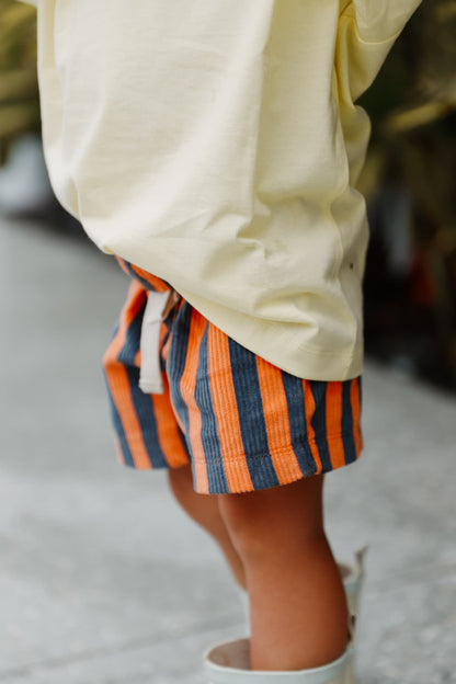 Cotton shorts for toddlers. Little Locker's Zinger shorts, in Navy/Orange. Featuring striped corduroy and an elastic waistband and drawstring.
