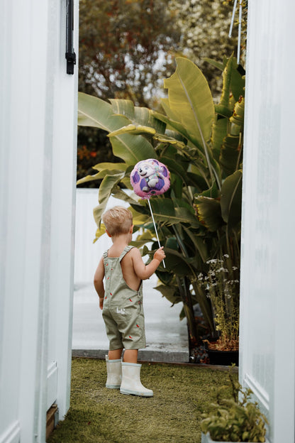 Toddler kid wearing sage green overalls ethically made in Bali from 100% cotton.