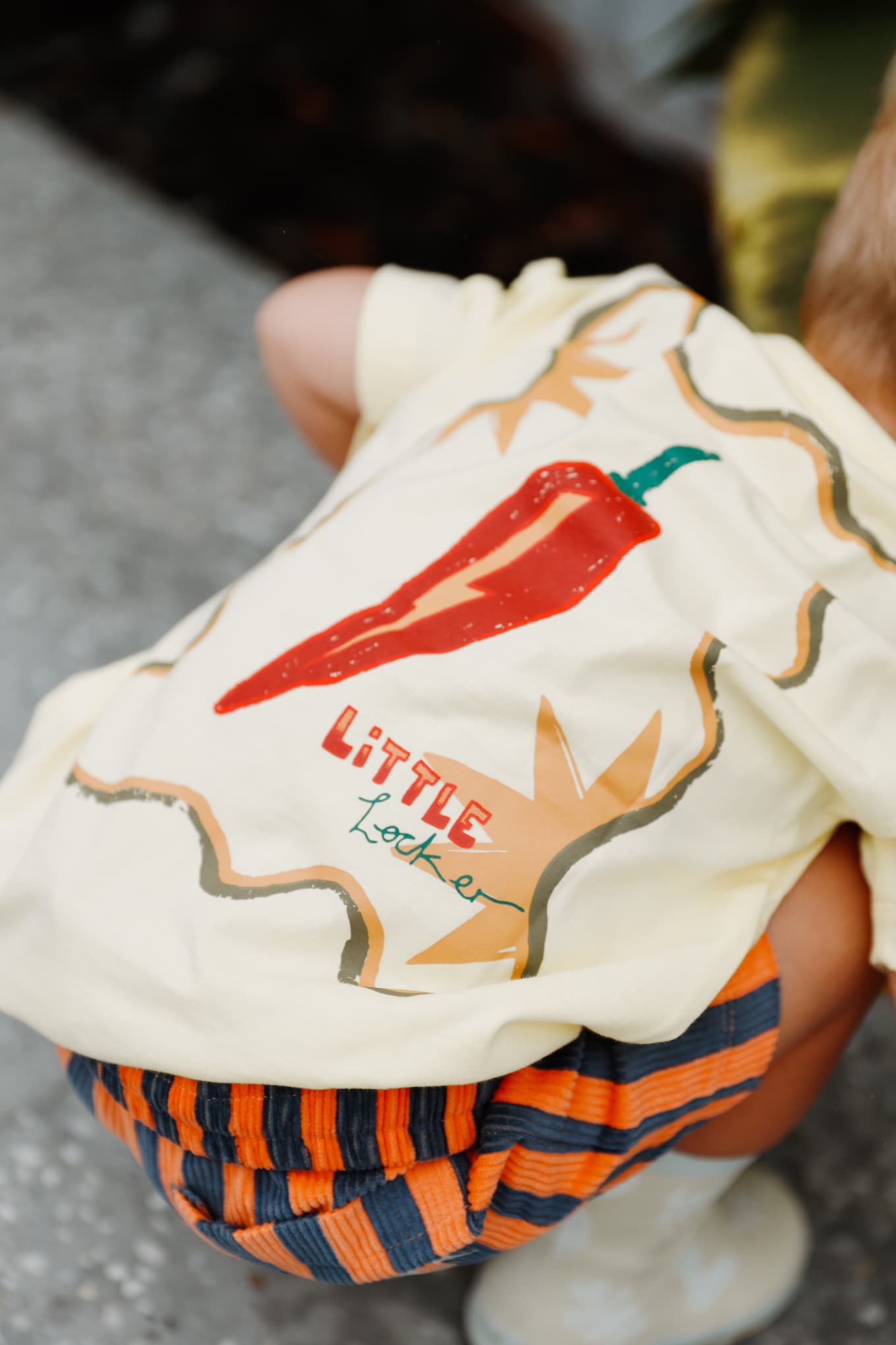 Toddler boy wearing a yellow graphic t-shirt with red chilli design and 'Little Locket' text.