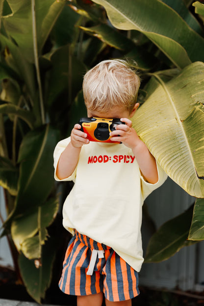Close up of Little Locker's sustainable ethically made cotton graphic MOOD: SPICY t-shirt in yellow.